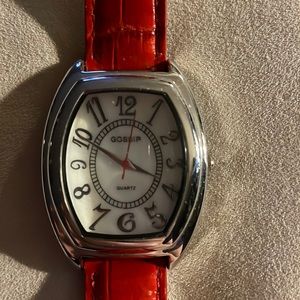 New watch. Never used. The face says Gossip and Quartz. The second hand is red.